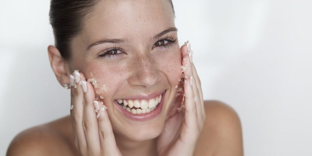 The girl prepares the skin for rejuvenation at home using exfoliation